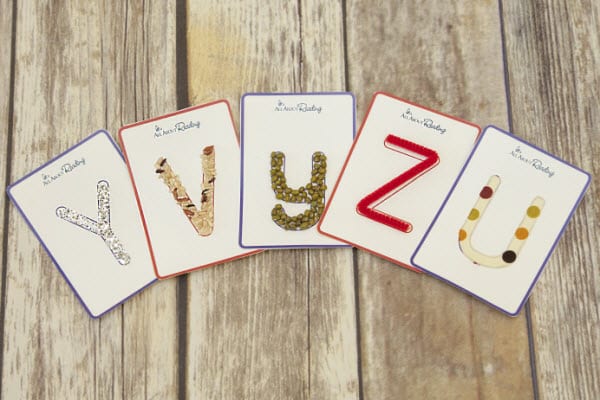 Letter cards with different tactile surfaces laid out on the floor as an example of alphabet activities