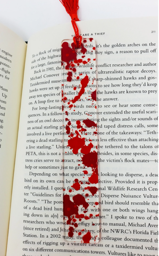 Blood splattered bookmark with red tassel.